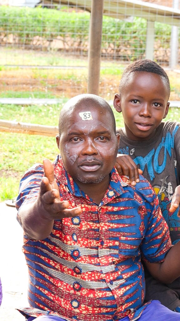 Kabafei Tchilabalo wuth his child after receiving cataract care in Togo.
