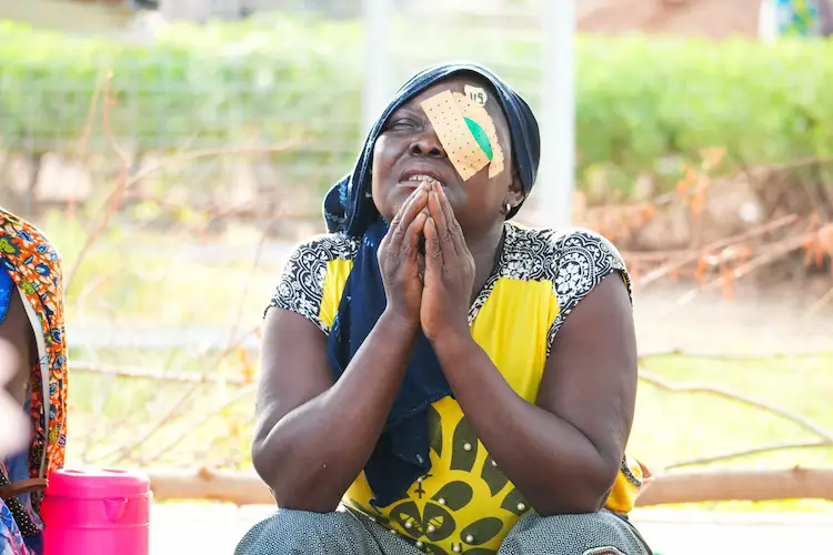 African women praying after receiving cataract surgery African women praying after receiving cataract surgery
